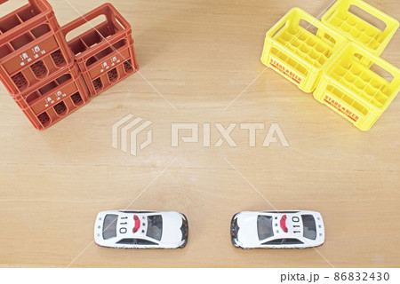 清酒とビールの箱と真ん中下に停車している2台のパトカー 86832430