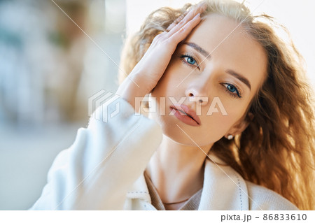 Close-up portrait of beautiful sensual woman looking to camera on sunny day over blur urban background Close-up portrait of beautiful sensual woman looking to camera on sunny day over blur urban background 86833610