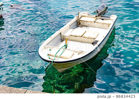 エメラルドグリーンの透き通った海に浮かぶ舟 エメラルドグリーンの透き通った海に浮かぶ舟 86834425
