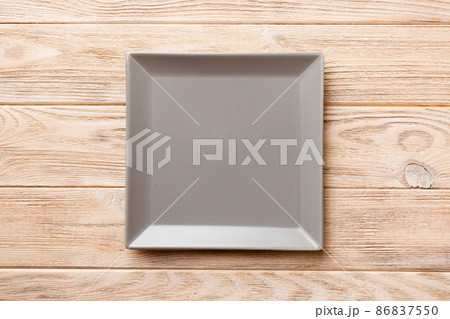 Top view of empty square plate on wooden background. Empty space for your design 86837550