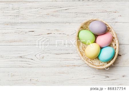 Multi colors Easter eggs in the woven basket on colored background . Pastel color Easter eggs. holiday concept with copy space 86837754