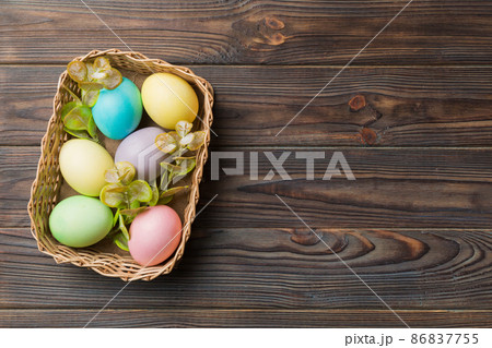 Multi colors Easter eggs in the woven basket on colored background . Pastel color Easter eggs. holiday concept with copy space 86837755