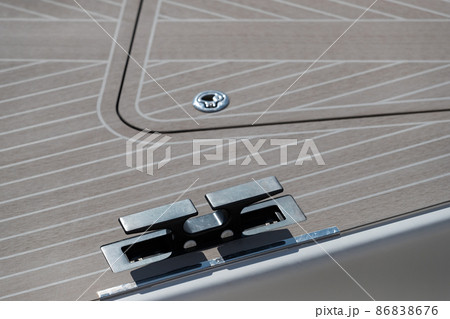 Close up view of front part of the boat at sunny day, bow of the boat, forepeak, hooks for a cable, the wooden deck, white color  86838676