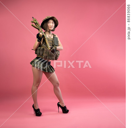 sexy Asian woman in military clothes with an automatic rifle in her hands while serving in the army sexy Asian woman in military clothes with an automatic rifle in her hands while serving in the army 86839066