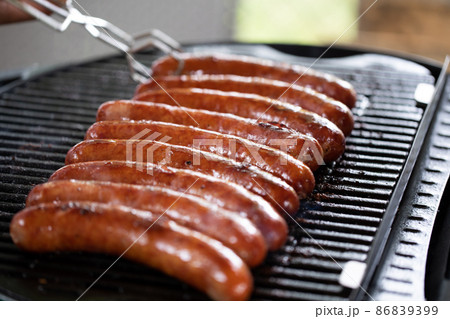 The sausage sits on the grill and gets grilled and the fat drips down the crust. The sausage sits on the grill and gets grilled and the fat drips down the crust. 86839399
