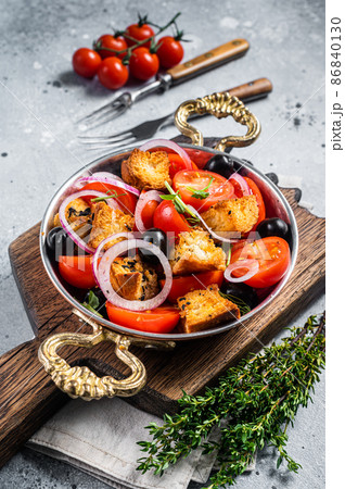 Panzanella traditional Italian salad with tomatoes, onion and bread Croutons. Gray background. Top view 86840130