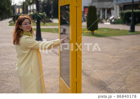 Caucasian woman using touch information board outdoors.  86840178