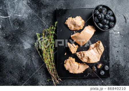 Foie gras duck liver pate and fresh blueberry. Black background. Top view. Copy space Foie gras duck liver pate and fresh blueberry. Black background. Top view. Copy space 86840210