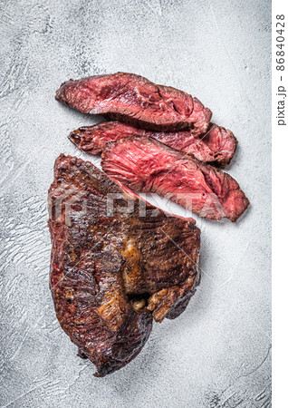 Roasted hanger or Onglet sliced beef meat steak on a table. White background. Top View 86840428