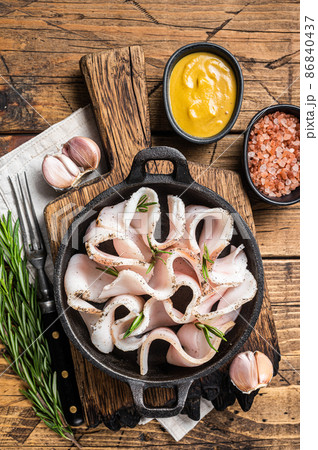Fresh sliced lard with salt, garlic and pepper in pan with herbs. Wooden background. Top view Fresh sliced lard with salt, garlic and pepper in pan with herbs. Wooden background. Top view 86840437