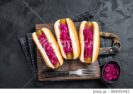 Homemade Vegan hot-dog with meatless Vegetarian sausage and cabbage. Black background. Top view 86840482