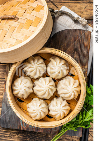 Momo dumplings in a bamboo steamer. Wooden background. Top view 86840504