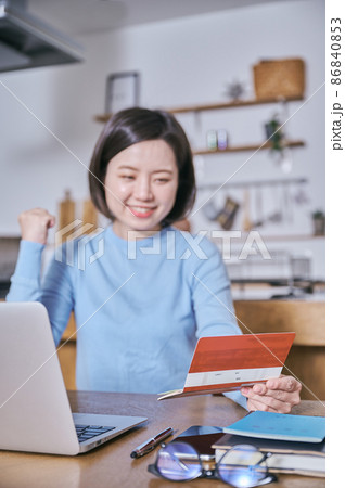 預金通帳を見てガッツポーズをする若い女性 預金通帳を見てガッツポーズをする若い女性 86840853