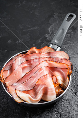 Cooking of Black Forest Ham in skillet. Black background. Top view Cooking of Black Forest Ham in skillet. Black background. Top view 86841111