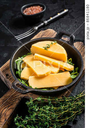 Halloumi cheese in pan ready for grilling. Black background. Top view 86841180