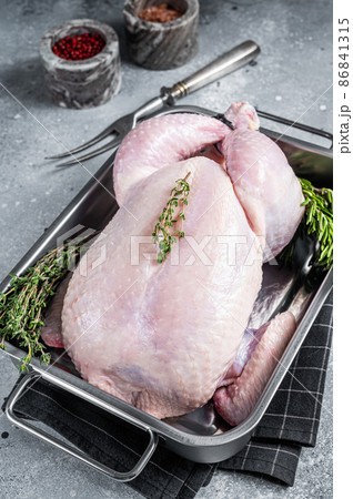 Whole raw Free range chicken in kitchen tray with herbs. Gray background. Top view Whole raw Free range chicken in kitchen tray with herbs. Gray background. Top view 86841315