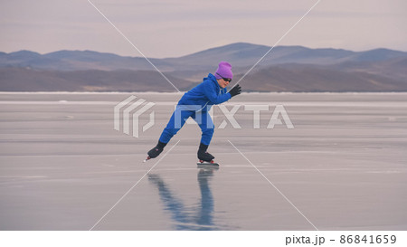 The child train on ice professional speed skating. The girl skates in the winter in sportswear, sport glasses, suit. Outdoor slow motion. The child train on ice professional speed skating. The girl skates in the winter in sportswear, sport glasses, suit. Outdoor slow motion. 86841659