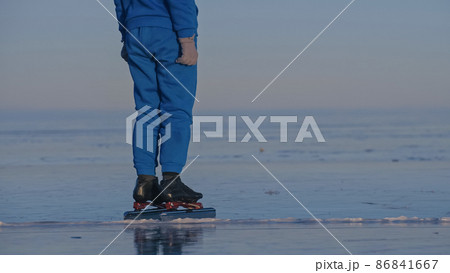 The girl train on ice speed skating. The child skates in the winter in blue sportswear suit, sport glasses. Children speed skating sport. 86841667