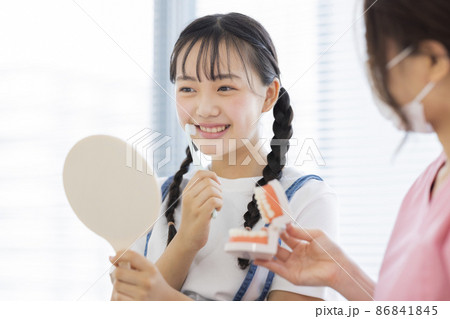歯科で歯磨きの指導を受ける女の子 歯科で歯磨きの指導を受ける女の子 86841845