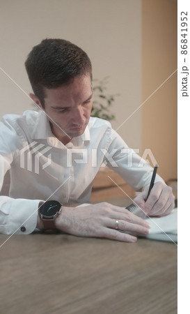 Businessman white shirt reading and signs documents Businessman white shirt reading and signs documents 86841952