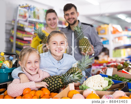 Happy parents with little girls with pineapples 86843403