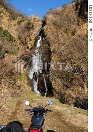 流れ落ちる滝を背景に佇むサイドカー 86843805