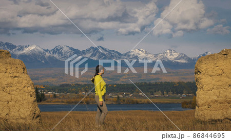 The woman in yellow green sportswear near old stone enjoying hig 86844695