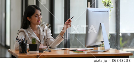 Charming businesswoman working on her pc computer. 86848288