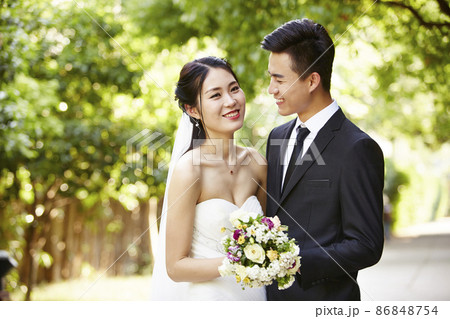 outdoor portrait of asian bride and groom, happy and smiling 86848754