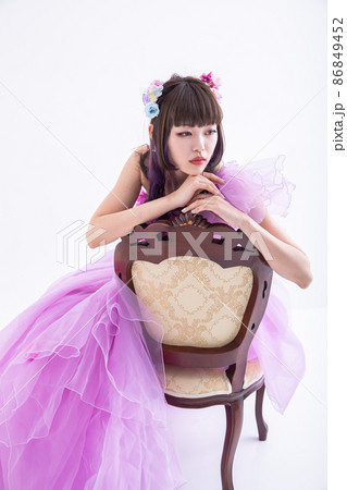 椅子に寄り掛かるドレスを着た女性　dress 86849452