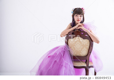 椅子に寄り掛かるドレスを着た女性　dress 86849453