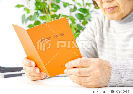 年金手帳を見るシニア女性 年金手帳を見るシニア女性 86850041
