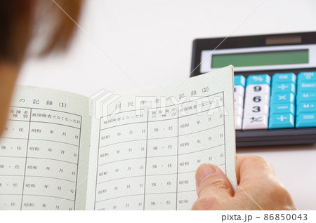 年金手帳を見るシニア女性 年金手帳を見るシニア女性 86850043