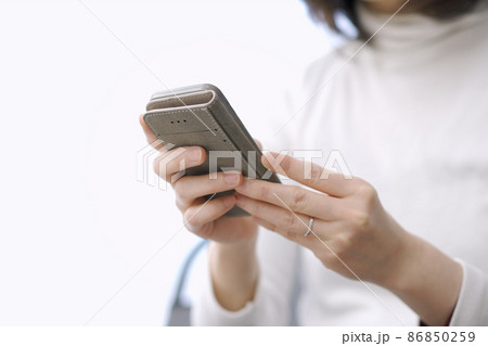 スマートフォンでテキスト入力をするアジア人の女性 スマートフォンでテキスト入力をするアジア人の女性 86850259