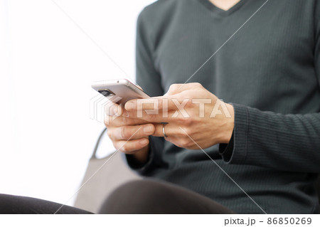 スマートフォンでテキスト入力をするアジア人の男性 スマートフォンでテキスト入力をするアジア人の男性 86850269