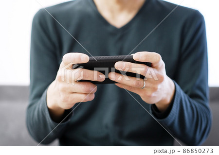 スマートフォンでゲームをするアジア人の男性 スマートフォンでゲームをするアジア人の男性 86850273