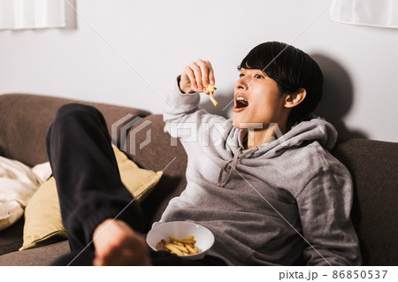 フライドポテトを食べながら映画を楽しむ男性 86850537