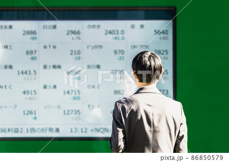 株価ボードを見る男性 86850579