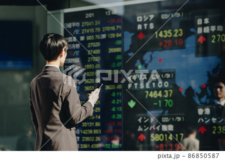 世界の市況をみる男性（株価ボード） 86850587