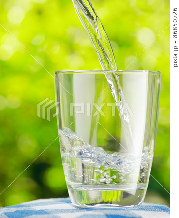Glass of water on nature background Glass of water on nature background 86850726