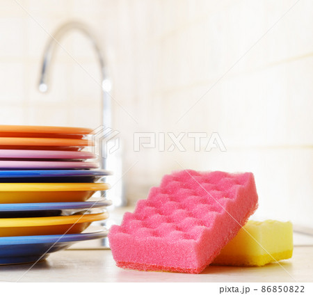 Several plates and a kitchen sponge. Dishwashing concept Several plates and a kitchen sponge. Dishwashing concept 86850822