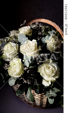 Bouquet of beautiful white roses in a wicker basket on a dark background. Perfect for greeting card 86852981