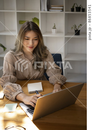 Attractive business woman checking financial data on laptop computer. 86853541