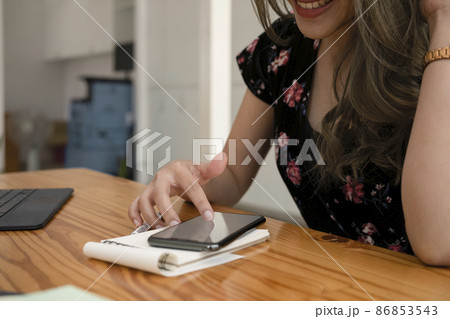 Smiling woman checking social media on her smart phone. 86853543
