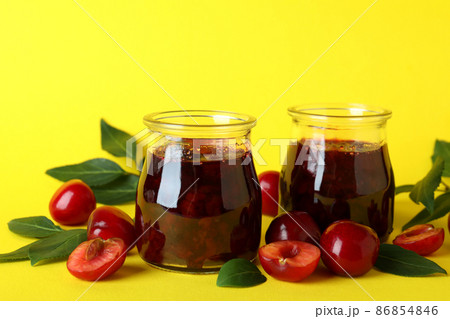 Cherry jam and ingredients on yellow background Cherry jam and ingredients on yellow background 86854846