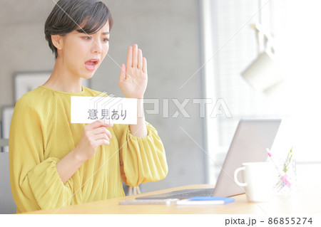 意見ありのフリップを見せ険しい表情でミーティングに参加するビジネスウーマン1 86855274
