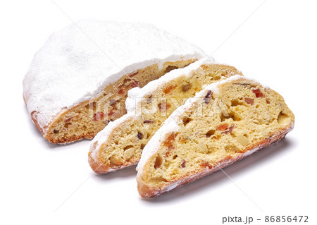 Sliced Traditional Christmas stollen cake with marzipan and dried fruit isolated on white background 86856472