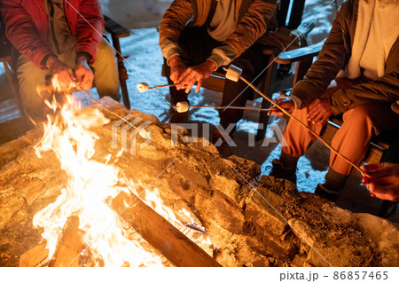 People cooking marshmallows during winter hike 86857465