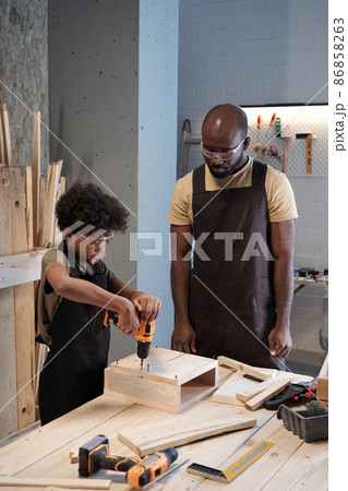 Father Teaching Son Carpentry in Workshop Father Teaching Son Carpentry in Workshop 86858263