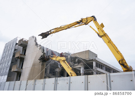 老朽化した公共建造物の解体作業をする重機 老朽化した公共建造物の解体作業をする重機 86858700